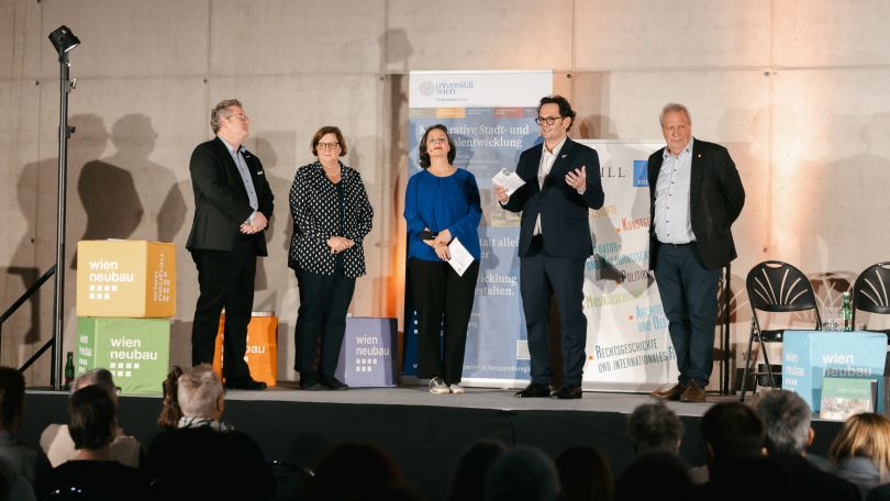 2 Frauen und 3 Männer sprechen vor Publikum.