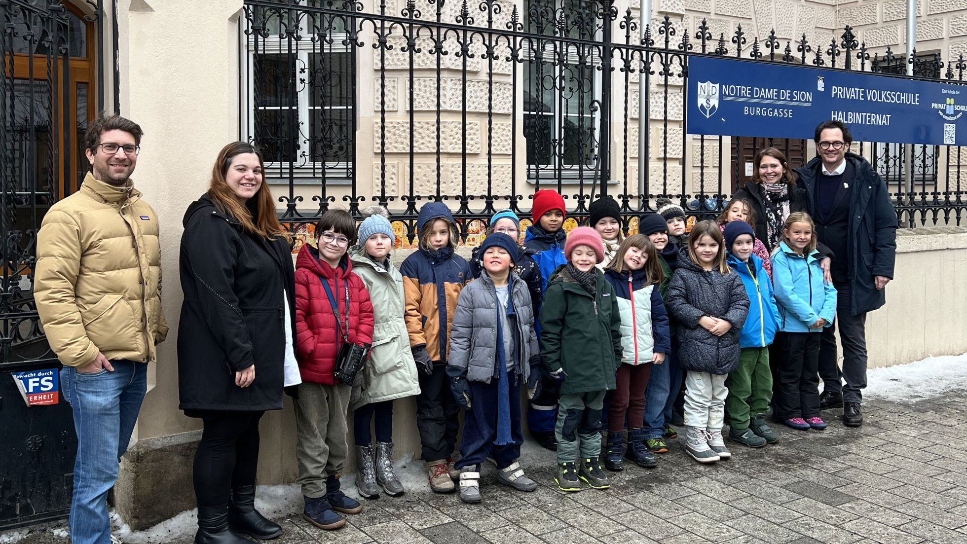 Gruppenfoto mit Kindern und dem Bezirksvorsteher vor der Schule Notre Dame in der Burggasse
