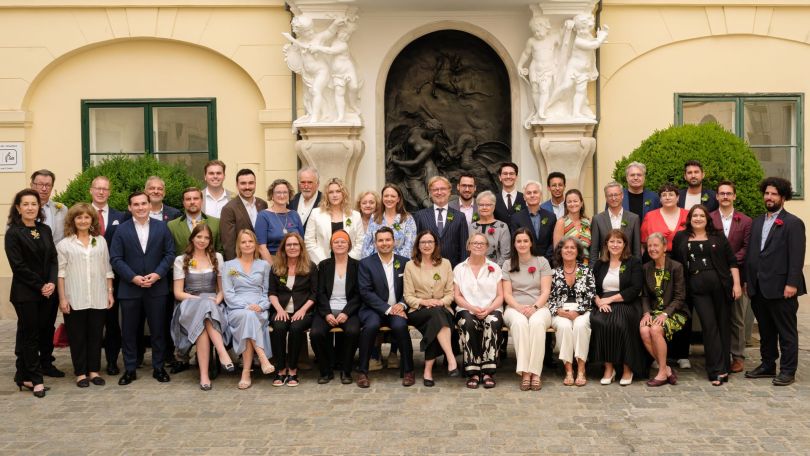 Gruppenfoto mit ungefähr 40 Personen im Freien vor einer Gebäudewand