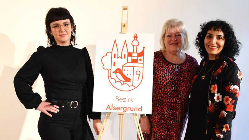 3 Frauen neben dem Bezirkslogo auf Leinwand