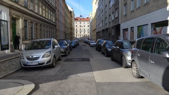Gasse mit parkenden Autos auf beiden Seiten