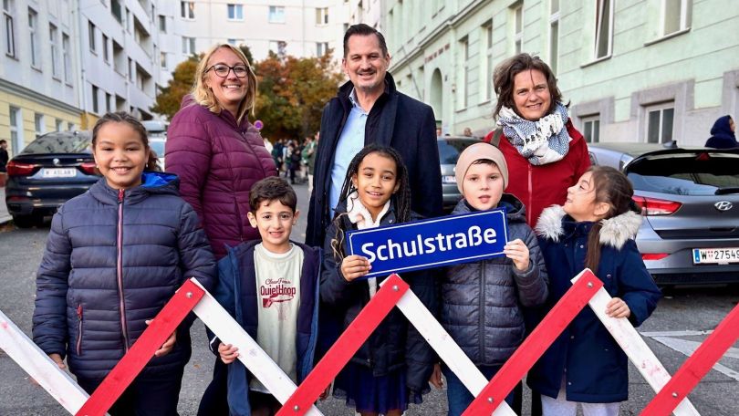 copyright: BV 10 Gruppenfoto mit Erwachsenen und Kindern vor einer Absperrung mit Schild "Schulstraßen".