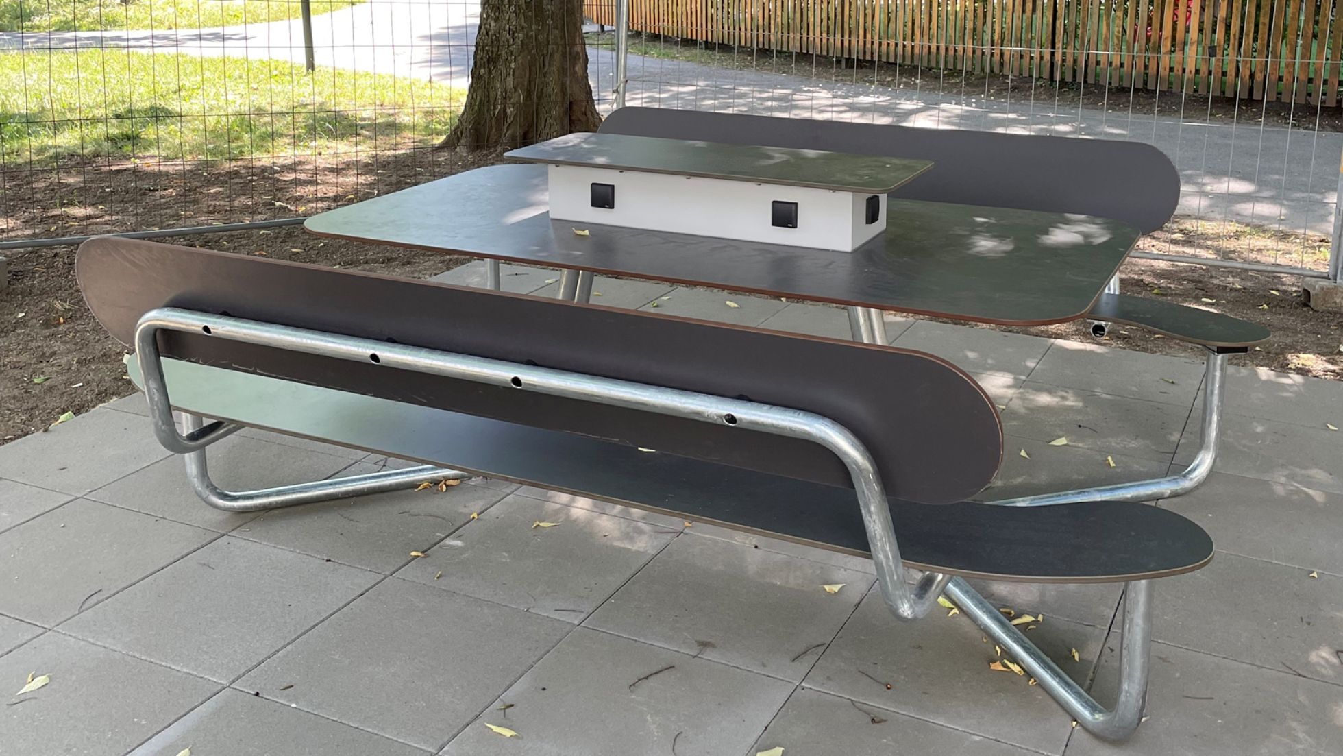 Eine Tisch-Bank-Kombination mit Stromanschluss in einem Park