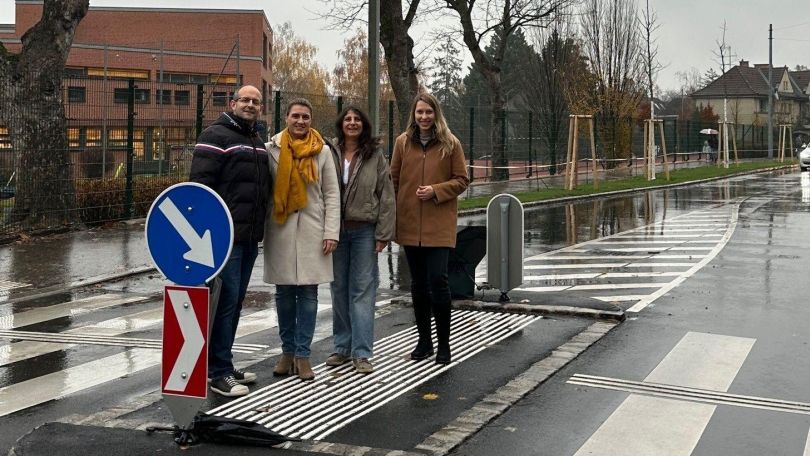 Mehrere Personen auf einer Querungshilfe mit Zebrastreifen.