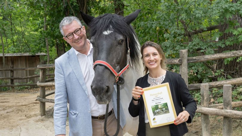 copyright: Daniel Zupanc Ein Mann hält ein Pferd am Halfter, eine Frau steht neben dem Pferd und hält eine Urkunde zur Tierpatenschaft in den Händen
