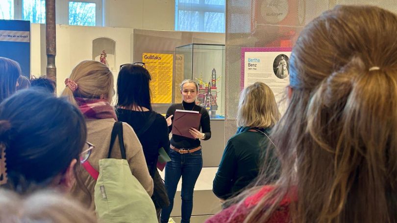 copyright: BV 14 Eine Frau mit Mappe in der Hand führt andere Frauen durch eine Ausstellung