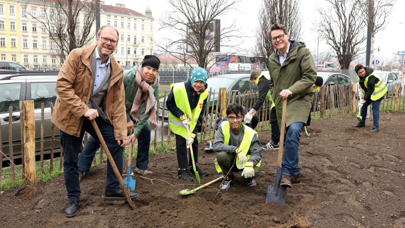 Bezirksvorsteher Dietmar Baurecht, Klimastadtrat Jürgen Czernohorszky und Schulkinder stechen einen Erdfläche um