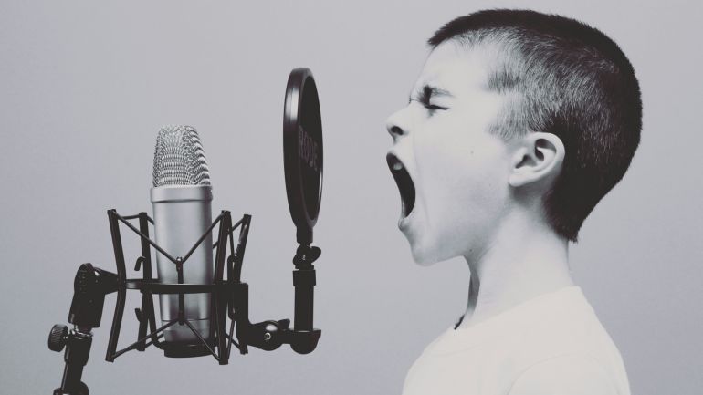 Ein Kind schreit in eine Mikrofon