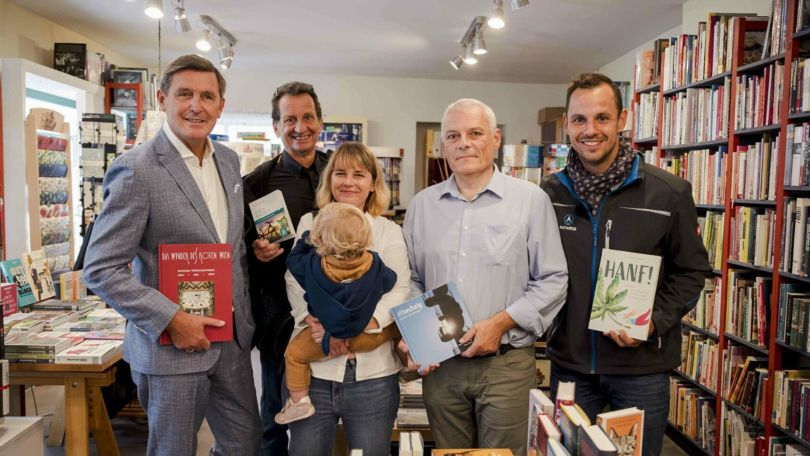 4 Männer, 1 Frau und ein Kleinkind in einer Buchhandlung