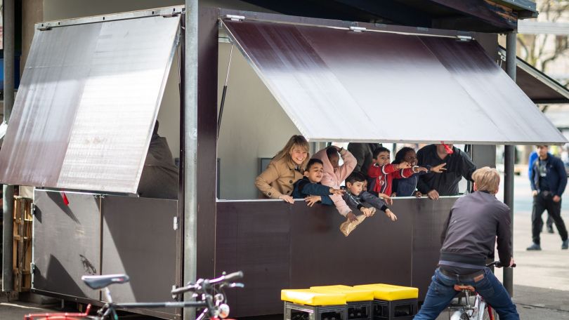 Mobile graue Beratungsbox aus der mehrere Leute herausschauen