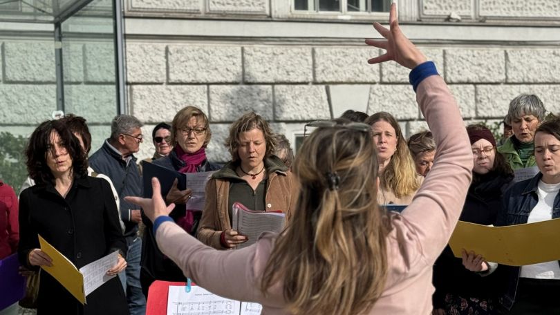Mehrere Frauen halten Notenbücher und singen im Chor