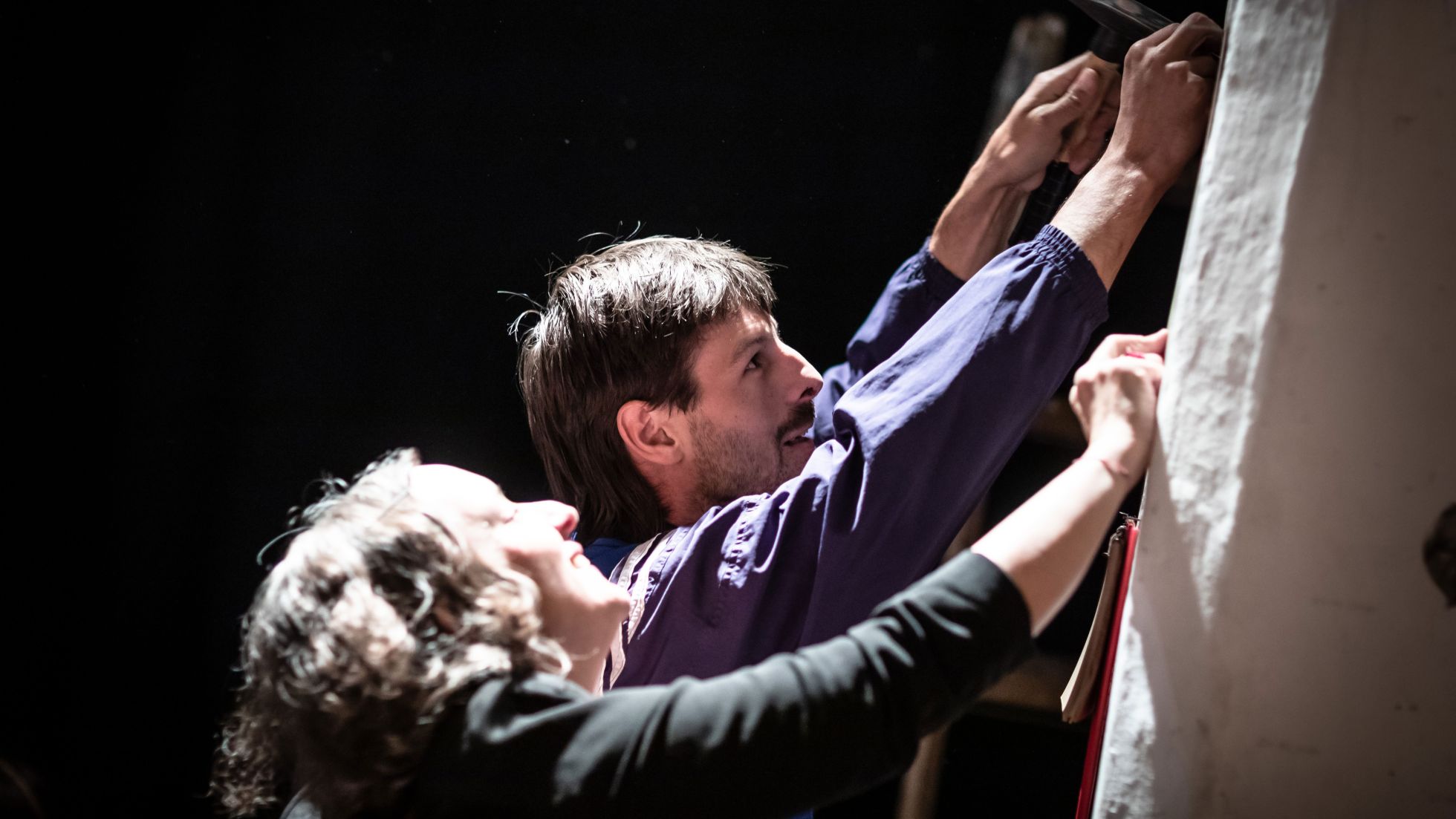 Eine Frau und ein Mann arbeiten an einer Leinwand