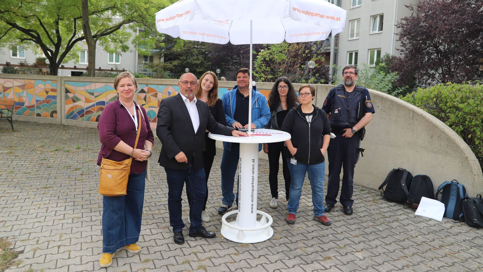 Bezirksvorsteher Peter Jagsch mit Bürger*innen im Gespräch, ein Polizist ist auch anwesend