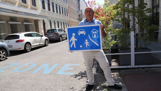 Bezirksvorsteher Peter Jagsch hält ein "Wohnstraße"-Schild