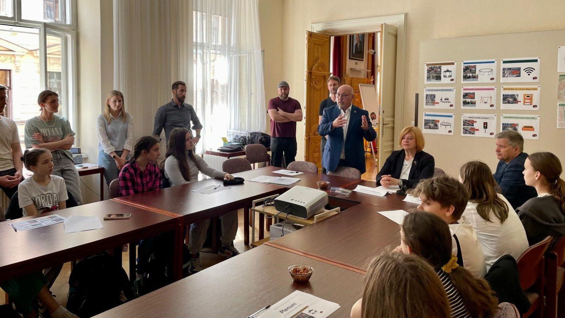 Jugendliche und Bezirksvorsteher sitzen bei Tischen und halten einen Workshop ab