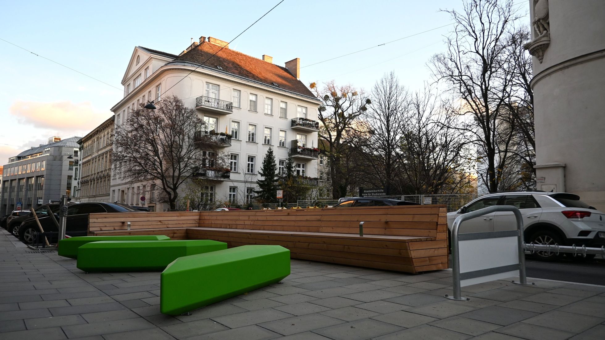 Verschiedene Sitzbänke aus Holz und in grün auf einem neu gepflasterten Platz