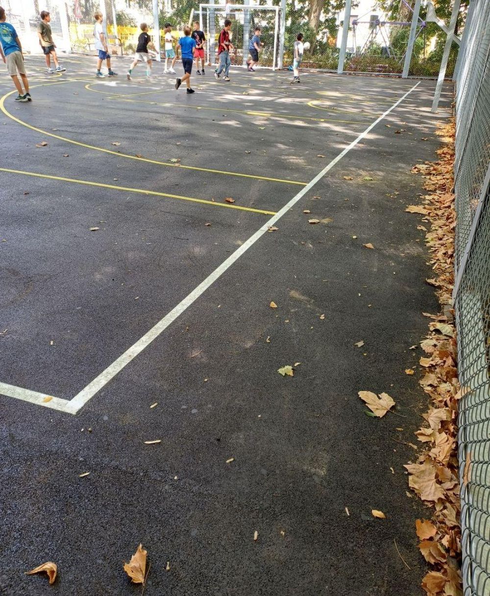 Der schon etwas desolate Belag im beliebten Ballsportkäfig wurde erneuert. Kinderspielen in einem Ballkäfig.