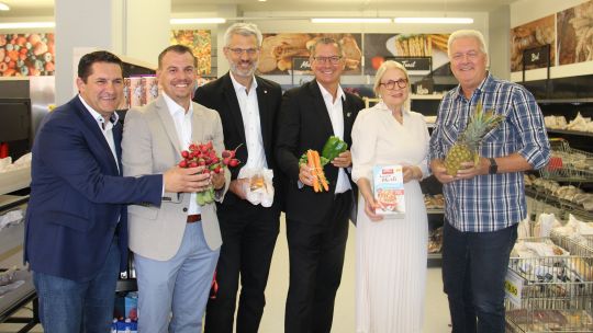 Bezirksvorsteher Georg Papai, Susanne Drapalik, Präsidentin des Samariterbund Wien, mit einigen Mitarbeiter*innen im Sozialmarkt