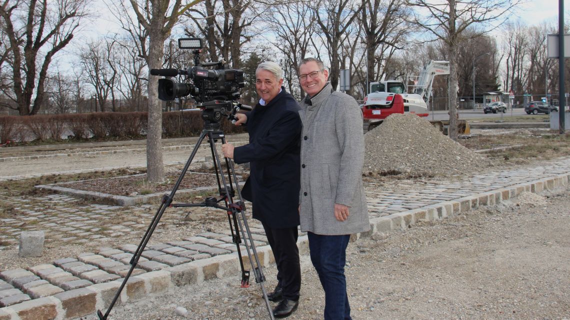 Bezirksvorsteher Papai und Nevrivy stehen neben einer Kamera im Freien