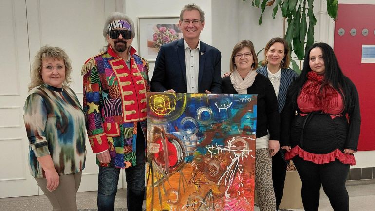 Bezirksvorsteher und Künstler*innen halten gemeinsames Kunstwerk