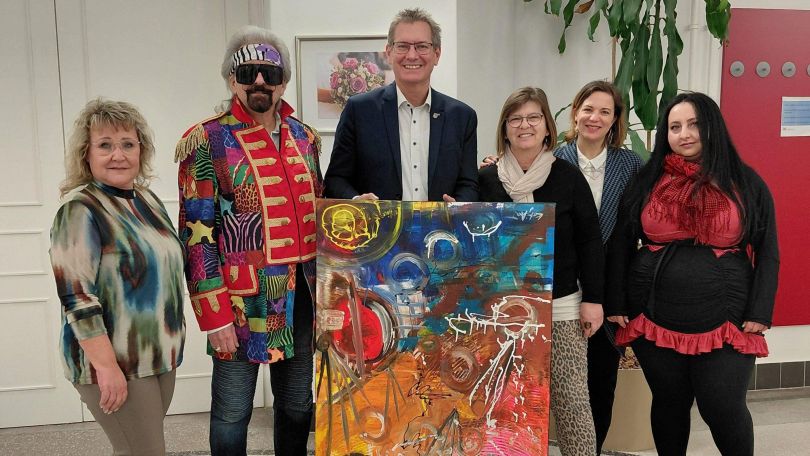 Bezirksvorsteher und Künstler*innen halten gemeinsames Kunstwerk