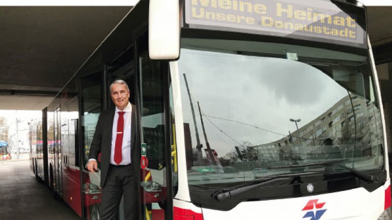 Bezirksvorsteher Ernst Nevrivy steigt aus dem Bus mit der Destination "Meine Heimat. Unsere Donaustadt"