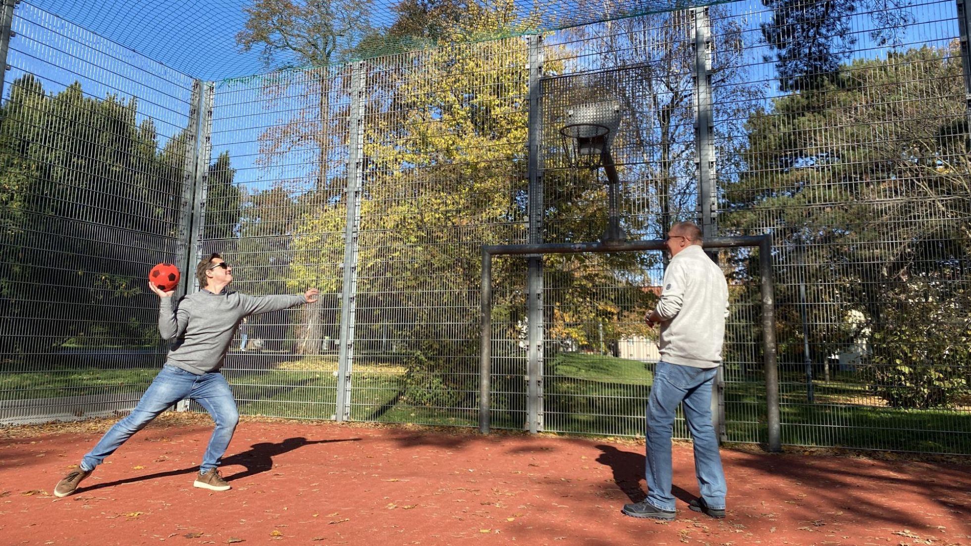 copyright: BV 23 / Esther Genitheim 2 Männer werfen Basketballkörbe am Ballspielplatz.