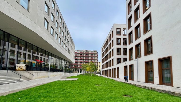 copyright: BV 23 Grüne Wiesenfläche zwischen 2 Gebäudeteilen des Bildungscampus Atzgersdorf.