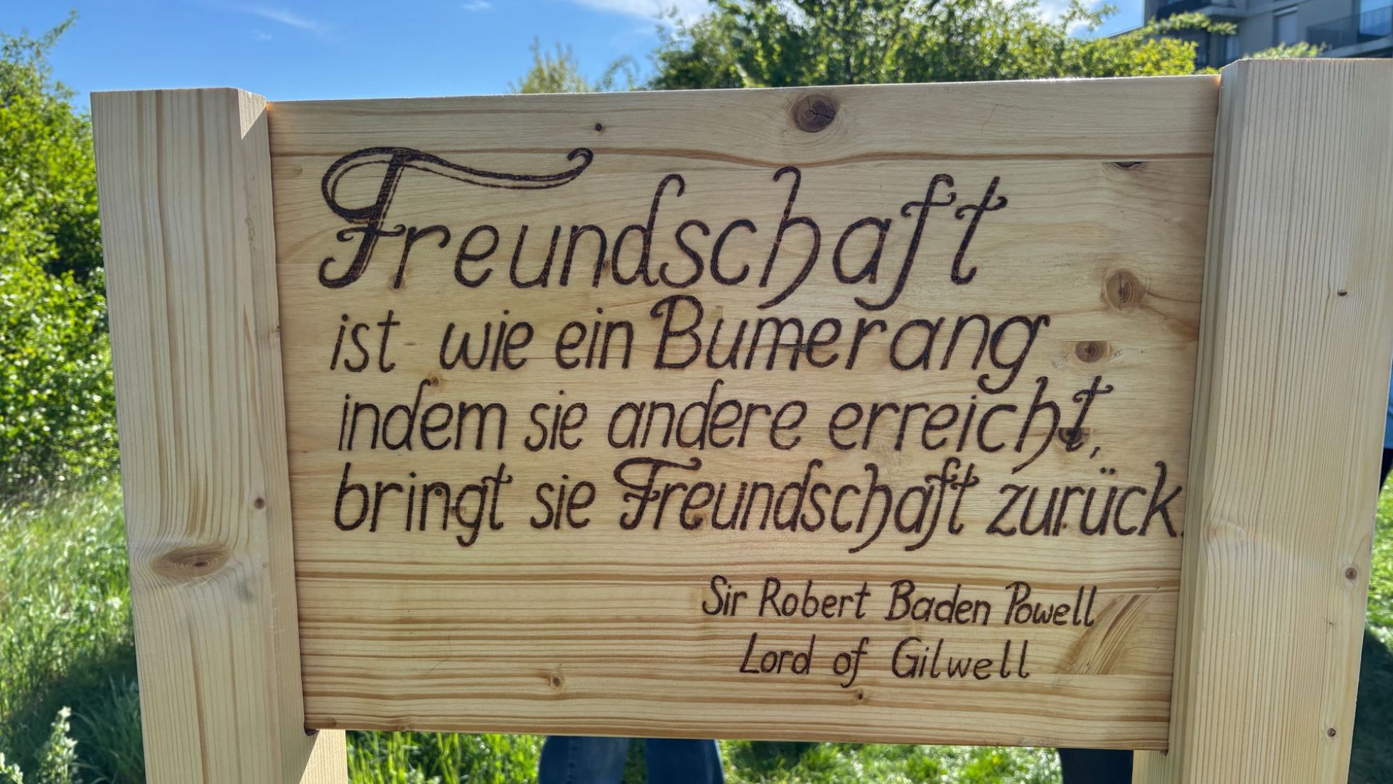 copyright: BV 23/Genitheim Holztafel mit einem Zitat von Sir Robert Powell: "Freundschaft ist wie ein Bumerang. Indem sie andere erreicht bringt sie Freundschaft zurück."
