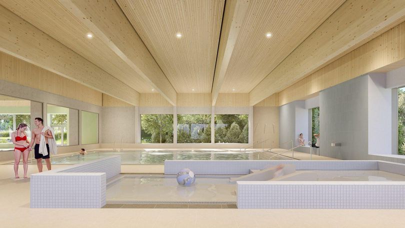 In einer hellen Schwimmhalle befindet sich ein seichtes Kinderbecken und dahinter ein Becken für Nicht-Schwimmer*innen.