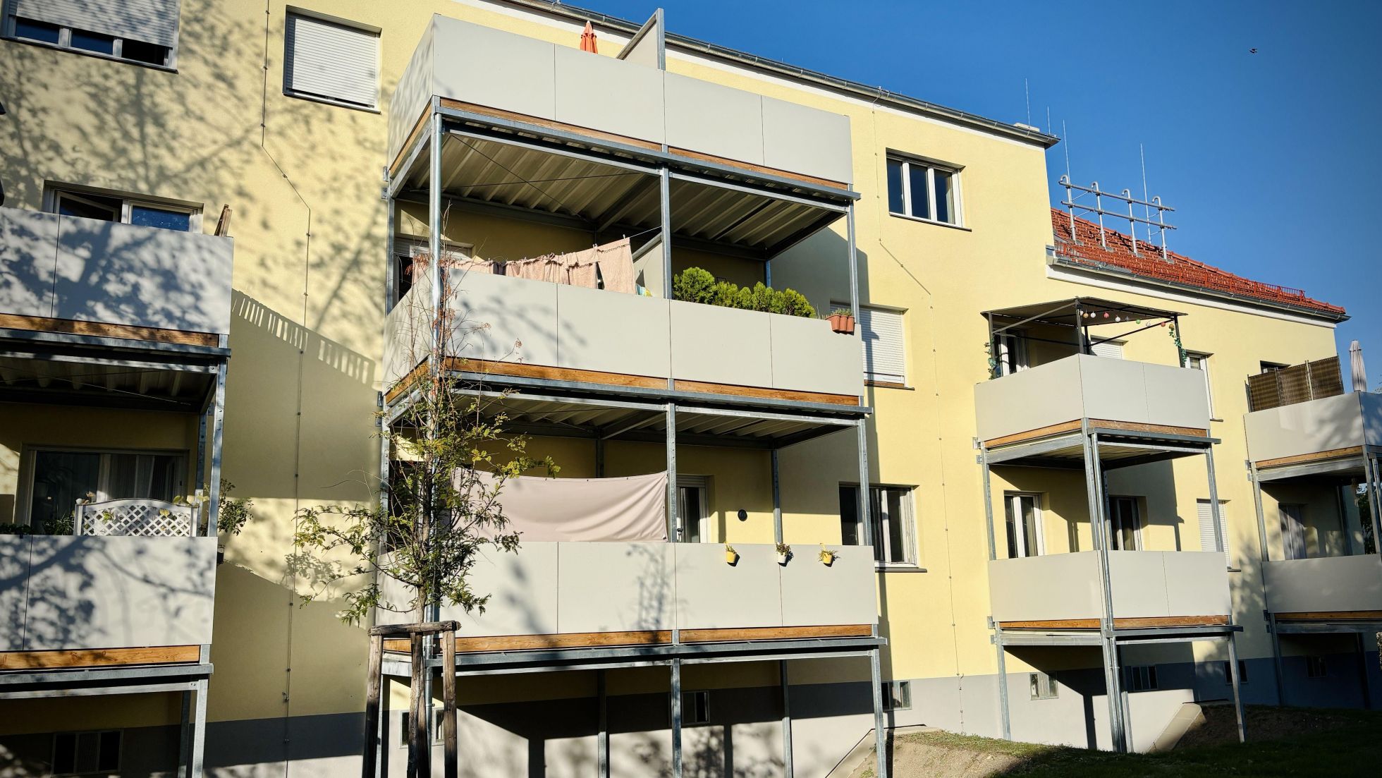 Hellgelbes Wohngebäude mit Balkonen