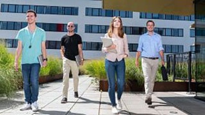 vier Menschen vor einem Gebäude