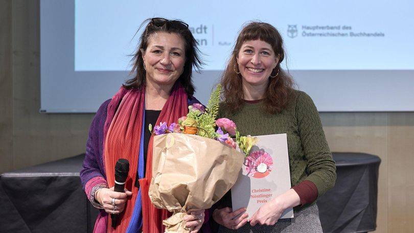 Stadträtin mit Blumenstrauß neben Preisträgerin