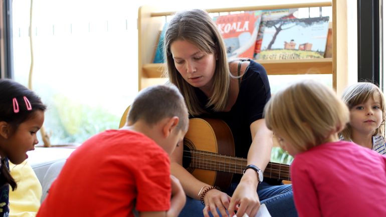 Pädagogin mit Gitarre betreut Kinder