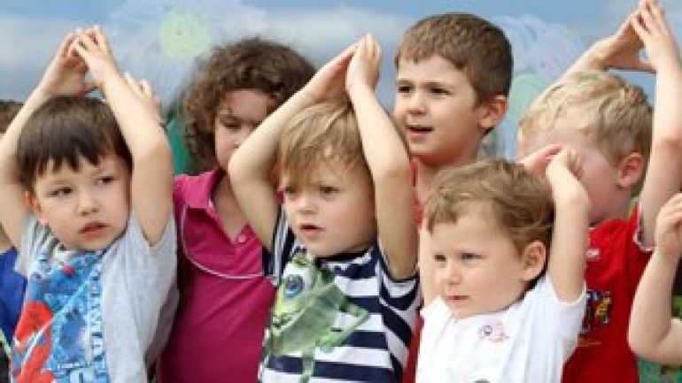 Kinder halten die Hände über den Kopf