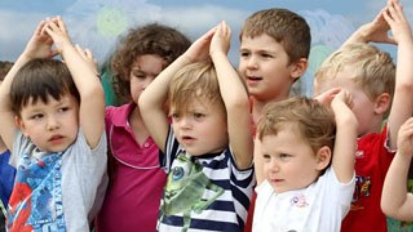 Kinder halten die Hände über den Kopf