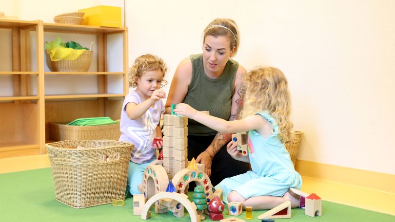 copyright: MA 10 - Wiener Kindergärten/VOTAVA Frau baut mit 2 kleinen Kindern einen Turm