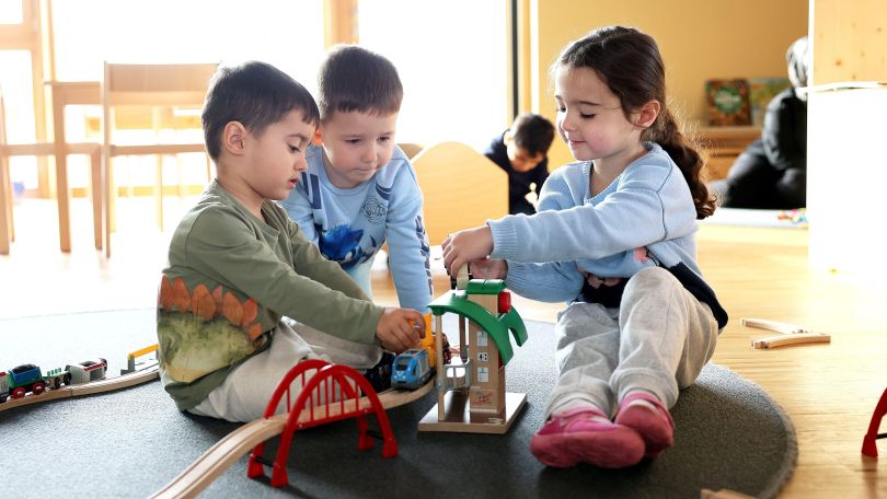 copyright: MA 10 - Wiener Kindergärten/VOTAVA 3 Kinder spielen mit einer Holzeisenbahn