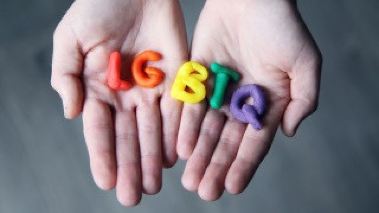 copyright: Sharon McCutcheon Handinnenflächen, auf denen die Buchstaben LGBTQ in Knetmasse liegen