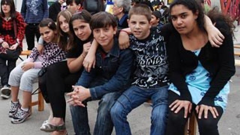 Jugendliche sitzen nebeneinander auf einer Bank