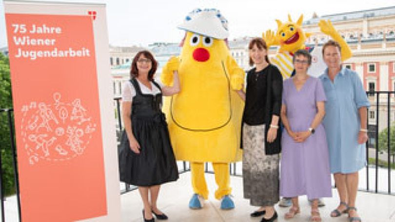 4 Personen posieren mit den beiden "Hollis", den Maskottchen der Offenen Wiener Kinder- und Jugendarbeit