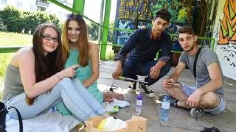 4 junge Menschen sitzen zusammen