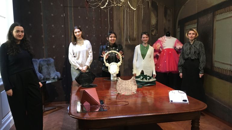 5 Frauen hinter einem Tisch mit Werken von Schülerinnen