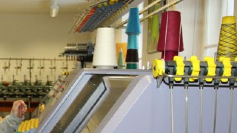 Schülerin bedient Strickmaschine