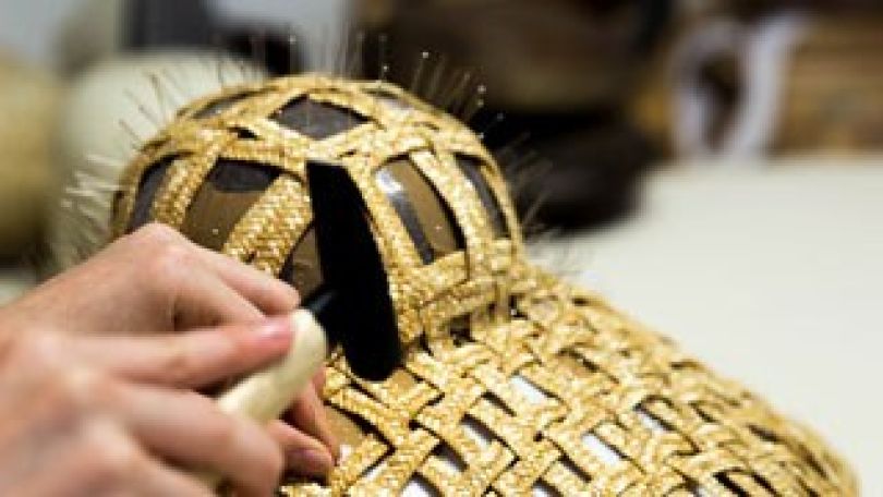 Schülerin befestigt geflochtene Bänder mit Nägeln