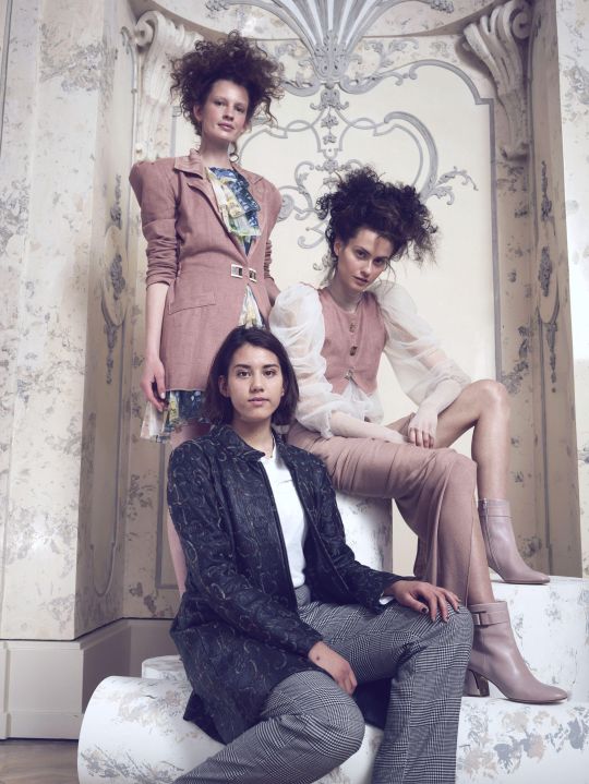Drei Models stehen bzw. sitzen auf 3 Sockeln.