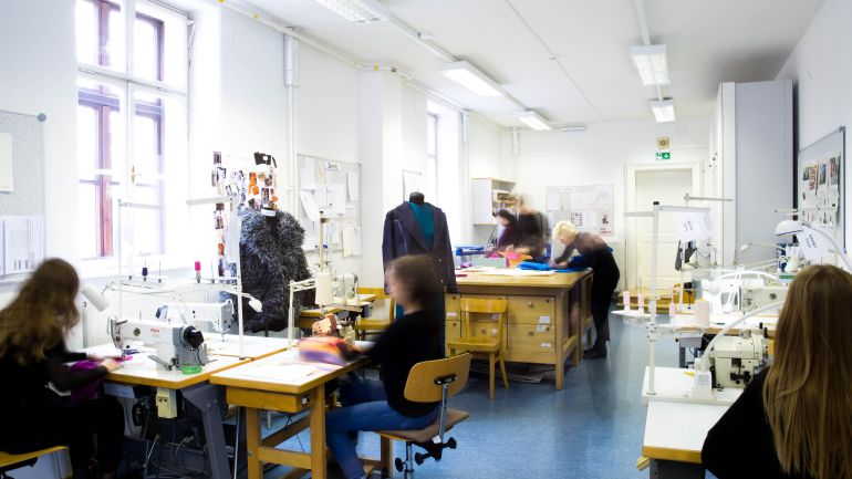 Schülerinnen der Modeschule nähen in einem Werkraum