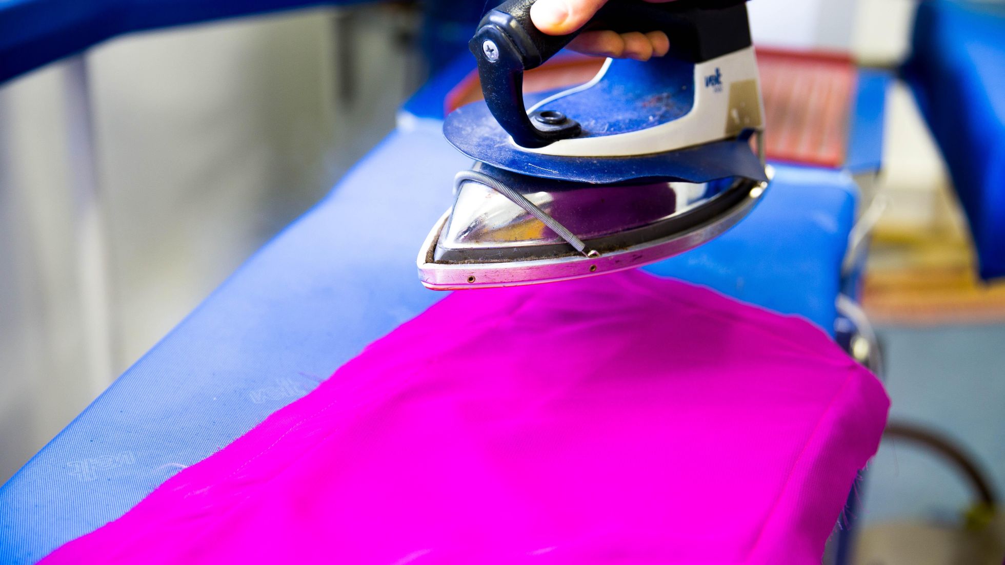 Pinker Stoff wird gebügelt