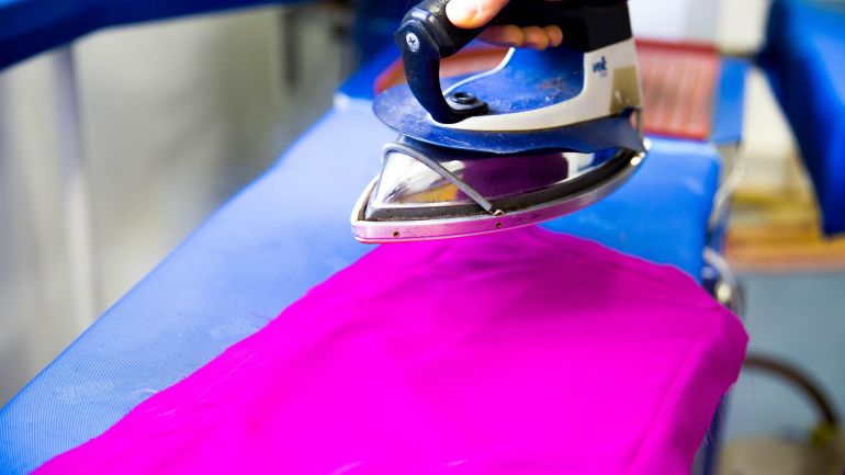 Pinker Stoff wird gebügelt