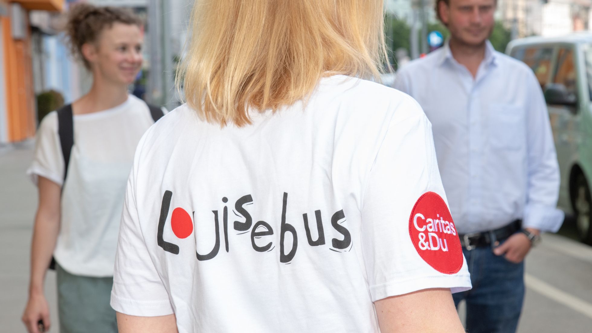 Junge Frau trägt T-Shirt mit Aufschrift "Louisebus"